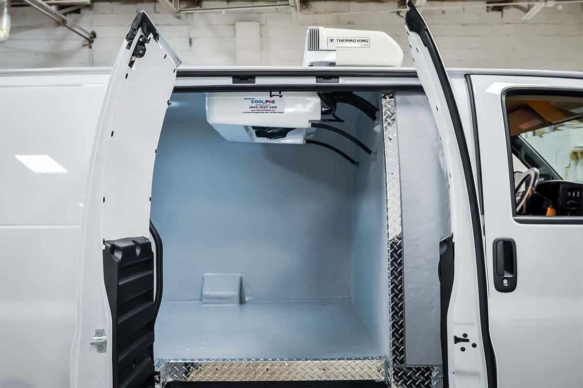 Technician measuring a refrigerated van interior for custom vehicle specifications