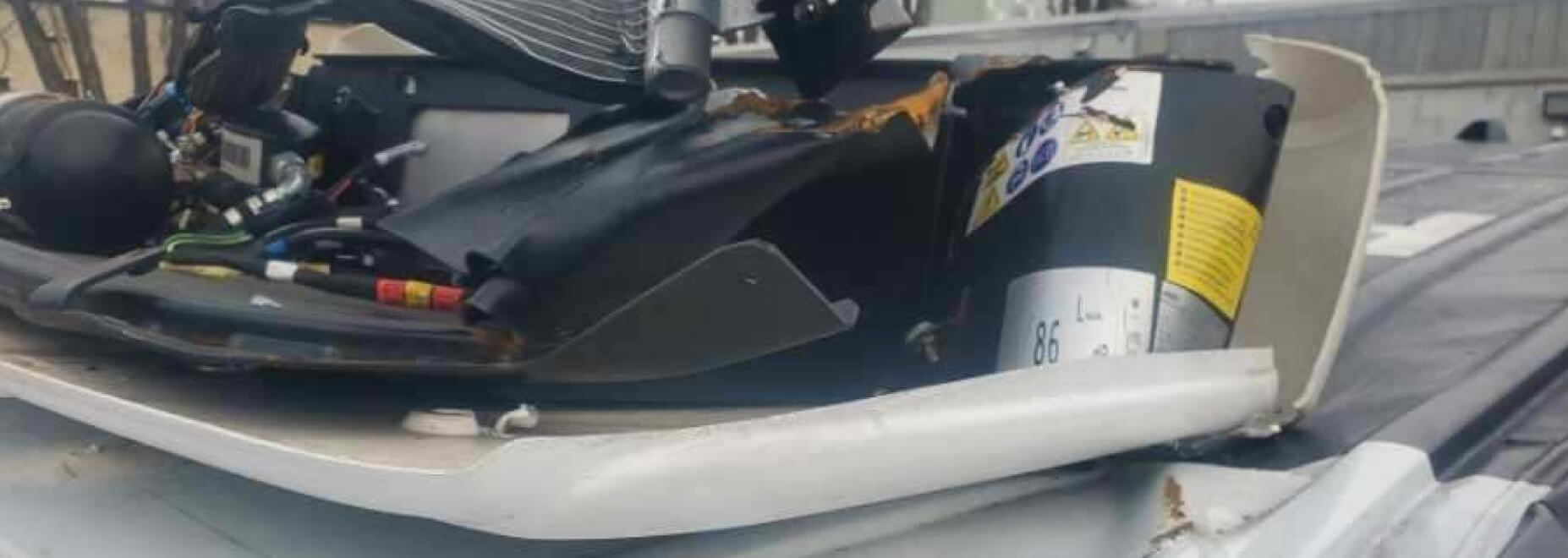 Close view of damaged refrigeration assembly before repair